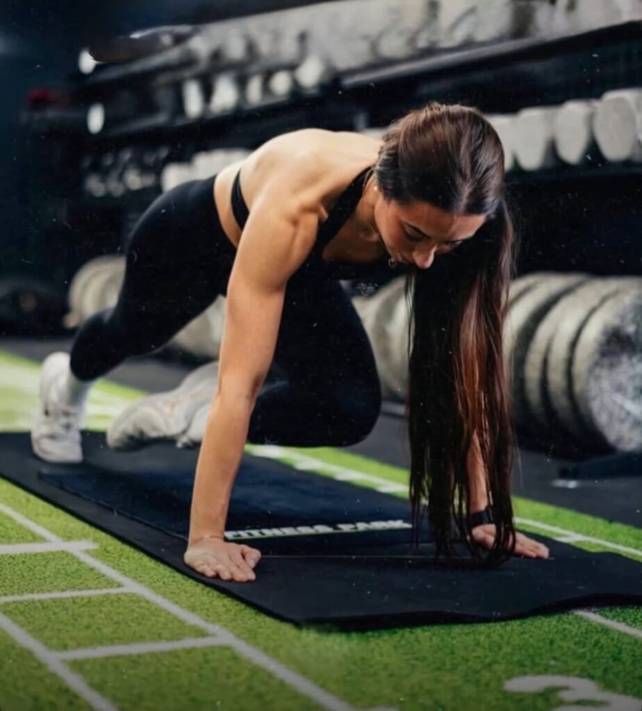 Ana entrenando en el suelo del gimnasio, concentrada