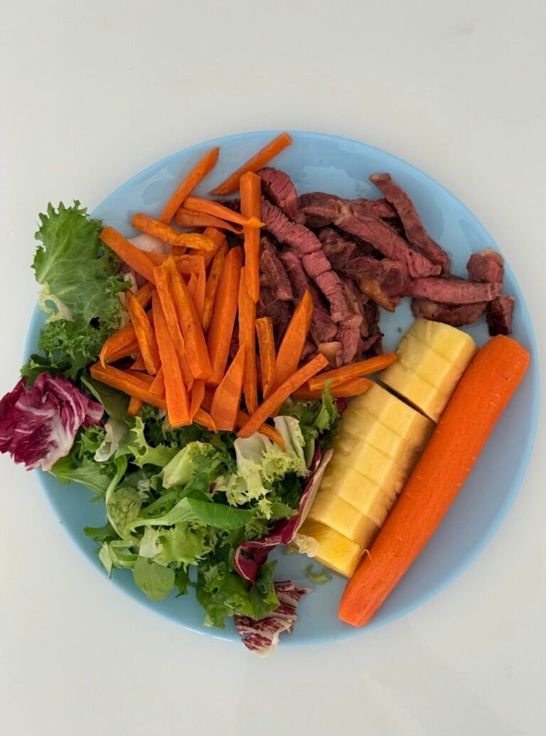 Plato con tiras de ternera, zanahorias, lechuga y piña.